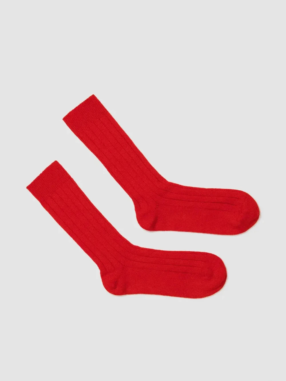 Pair of red socks on a light gray background